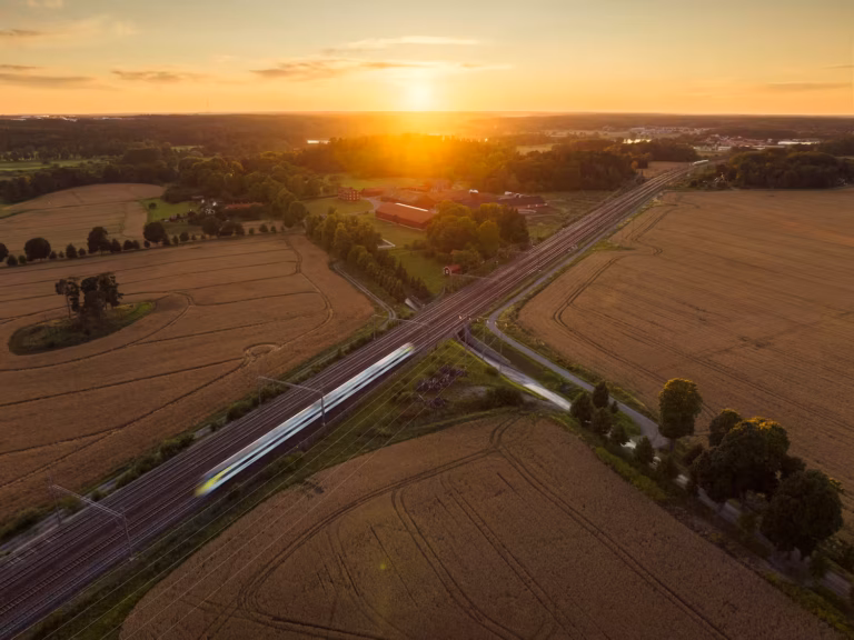 Ett tåg som kör mellan åkrar